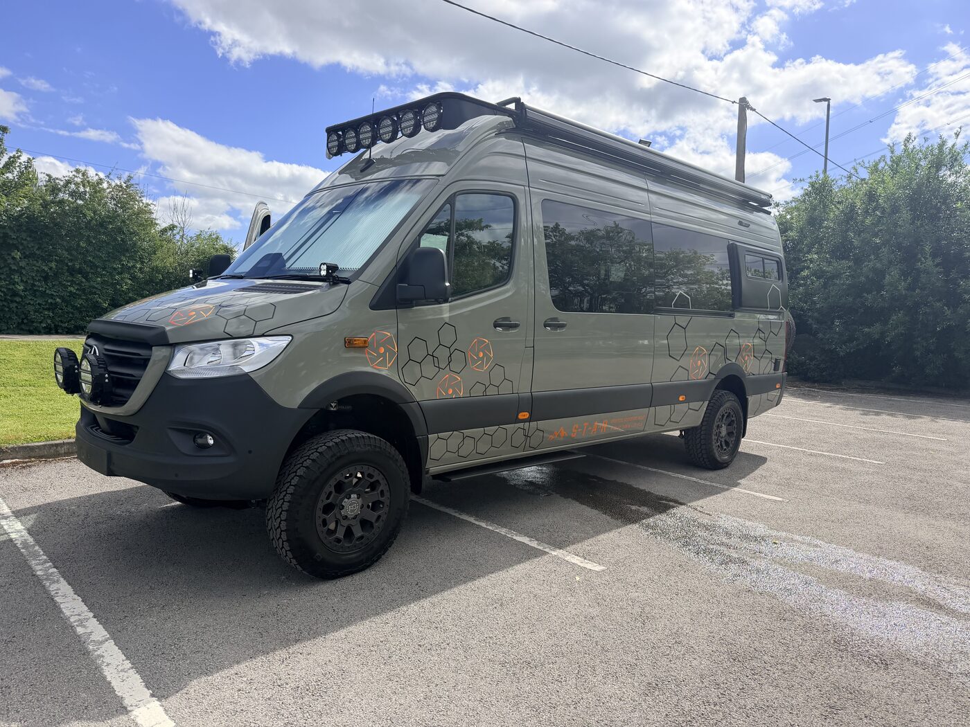 Blackstone 001 Outpost — matte obsidian black Mercedes Sprinter LWB side profile parked in the Scottish Highlands